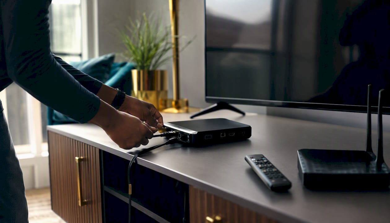 Hands connecting cables to a streaming device